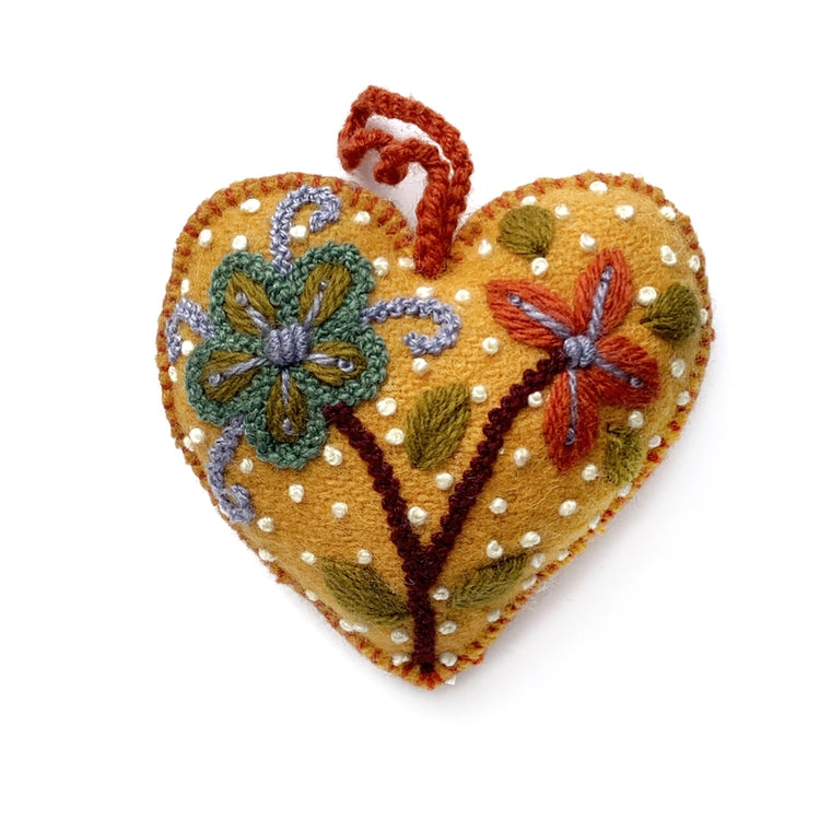 Heart-shaped golden embroidered felt ornament with floral patterns on a white background