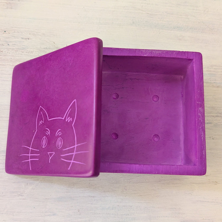 Magenta box with a cat design on a light wooden surface