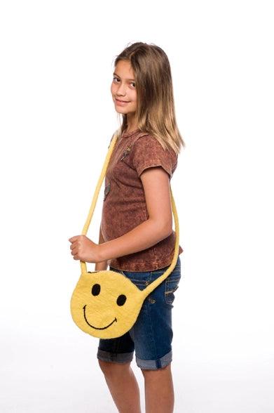preteen girl holding a yellow smiley face bag on a white background