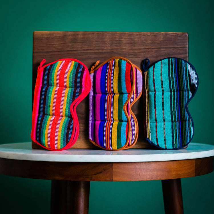 butterfly potholders on a marble table leaning against a wooden block