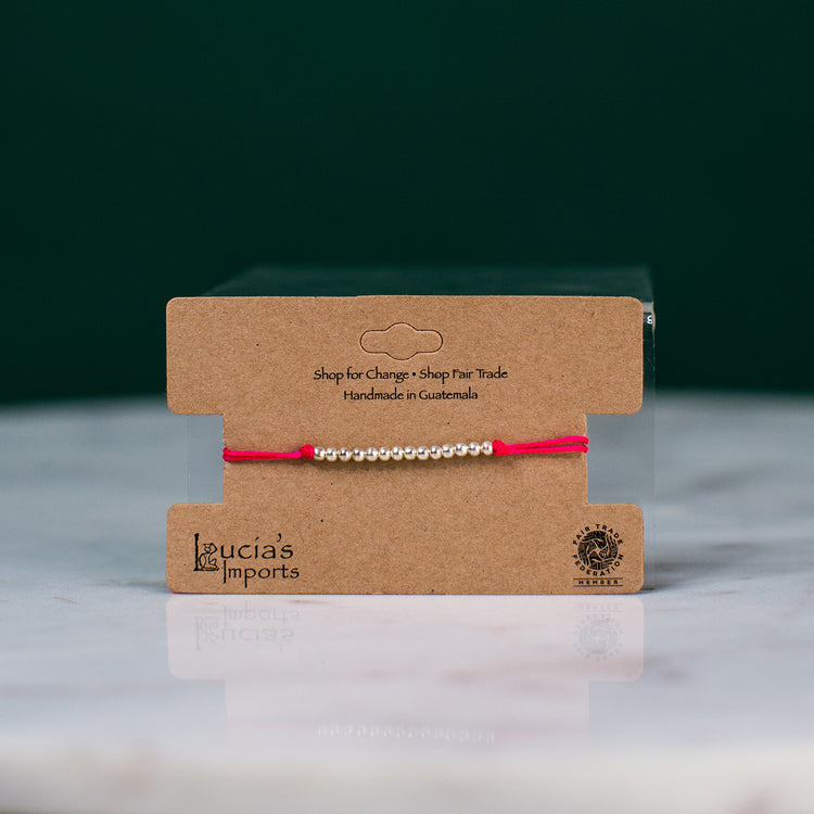 red string bead bracelet on display card