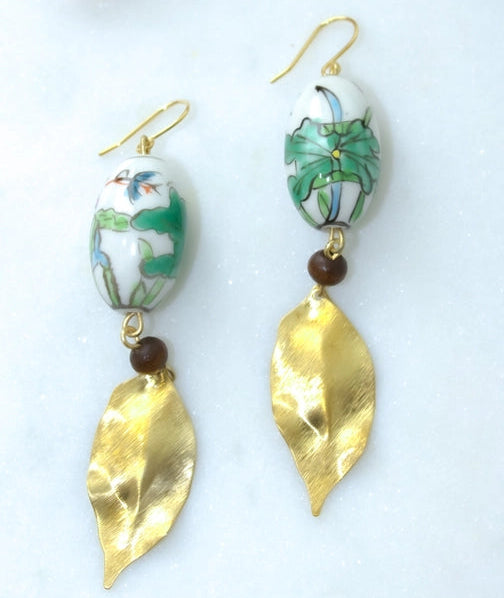 Pair of earrings with floral design and gold leaf accents on a white background