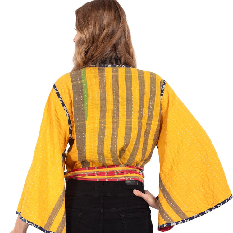 The back of a colorful  yellow patterned  top with bell sleeves. Made from Upcycled Kantha fabric.