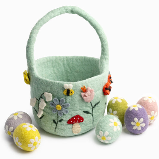 Decorative felt easter basket with floral and mushroom designs, accompanied by matching eggs on a white background.