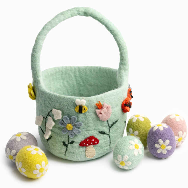 Decorative felt easter basket with floral and mushroom designs, accompanied by matching eggs on a white background.