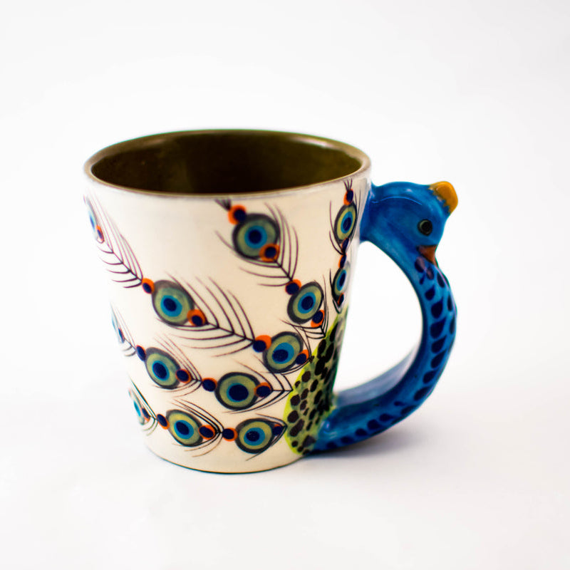 Ceramic mug with peacock feather design on a white background