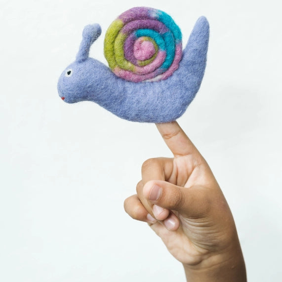 Hand holding a small felt snail finger puppet with a colorful shell against a white background