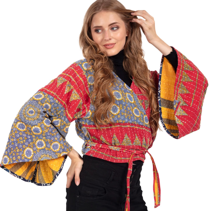 Woman wearing a colorful patterned  top with bell sleeves. Made from Upcycled Kantha fabric.