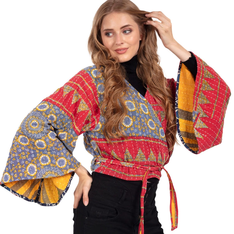 Woman wearing a colorful patterned  top with bell sleeves. Made from Upcycled Kantha fabric.