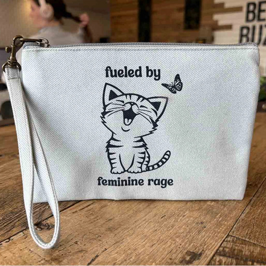 White pouch with a cat illustration and text that says fueled by feminine rage 