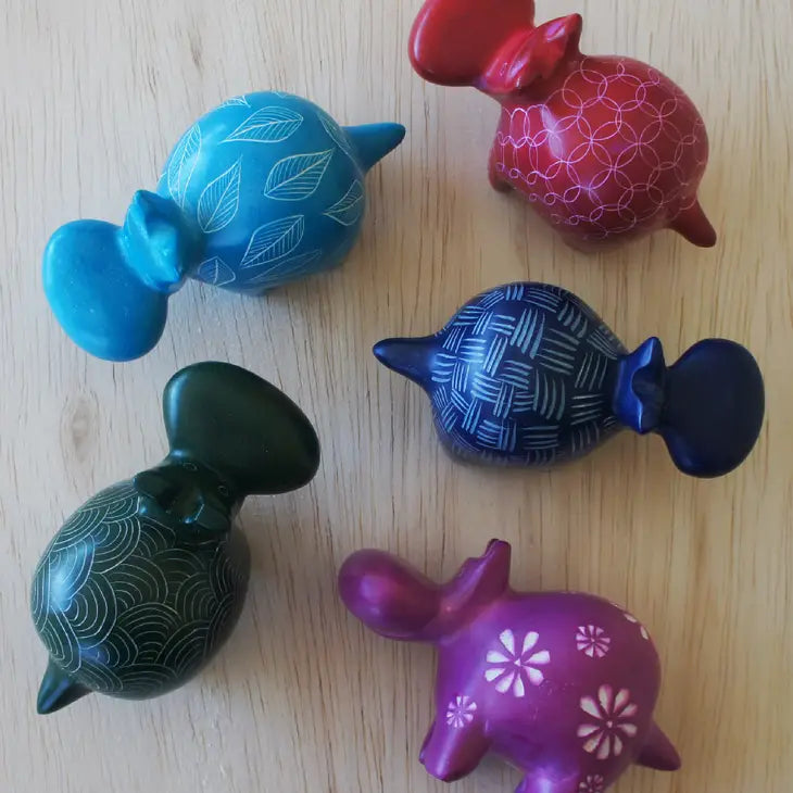 Top view of five hand-carved soapstone hippos of different colors