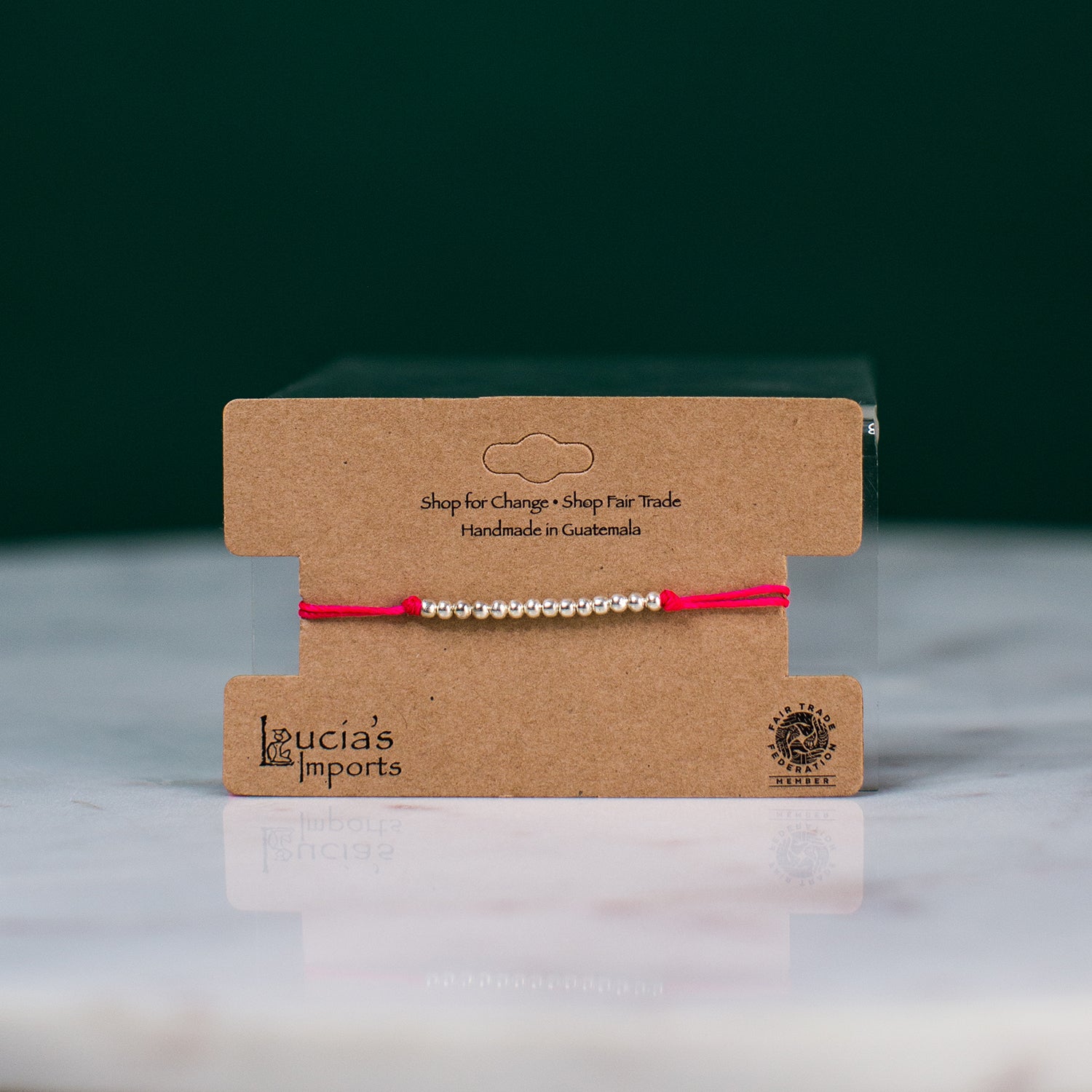 red string bead bracelet on display card