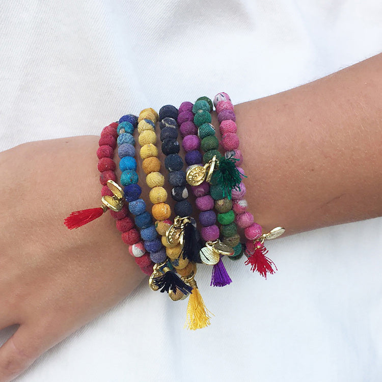 woman wearing every color of kantha bead bracelet